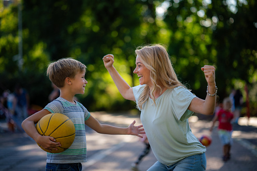 Mother supporting her little basketball player in nature