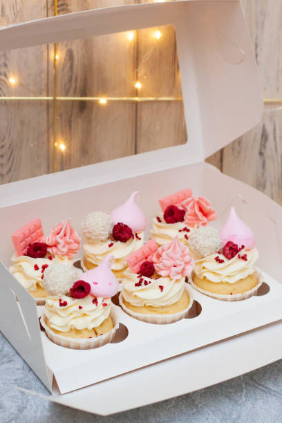 istock Gift box with beautiful pink cupcakes decorated with mini chocolate bars, meringue, raspberry and cream cheese frosting 1638145433