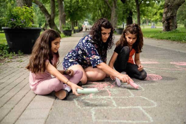 istock Mother of middle-eastern ethnicity playing with two active daughters in park. 1638161779