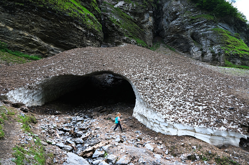 Cirque du Fer-a-Cheval, Haute Savoie, France - July 6, 2021. Cirque du Fer-a-Cheval with Bout du Monde, the most grand alpine mountain cirque, limestone of 4 to 5 kilometers of development, walls of 500-700m high, Haute- Savoie, France.  Ice Cave on the trail.