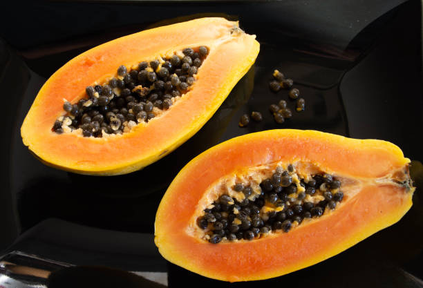 istock Papaya sliced in half on a black plate 1638234188
