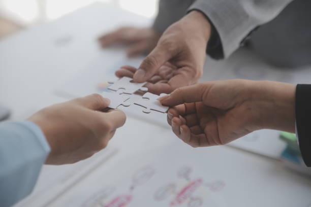 plan recadré de la main d’une femme d’affaires reliant le puzzle avec l’effet de lumière du soleil, solutions commerciales, succès et assemblage de pièces de puzzle, idées de stratégie. - office tool flash photos et images de collection