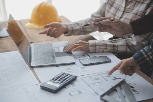 istock Construction and structure concept of engineer working drawing on blueprint meeting for project working with partner on model building and engineering tools in working site, construction concept. 1638269318