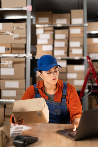istock Online store manager using laptop, preparing a parcel for postage. Small Business Owner working in storeroom, Preparing order for buyer. 1638276568