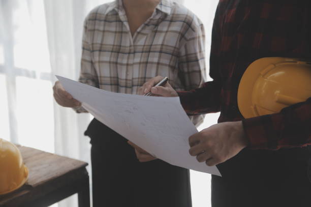 istock Construction and structure concept of engineer working drawing on blueprint meeting for project working with partner on model building and engineering tools in working site, construction concept. 1638290290