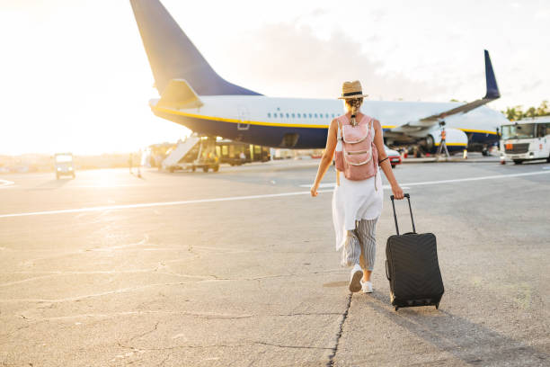 vue arrière d’une femme marchant vers l’avion, prête à embarquer et à commencer ses vacances - aéroport photos et images de collection