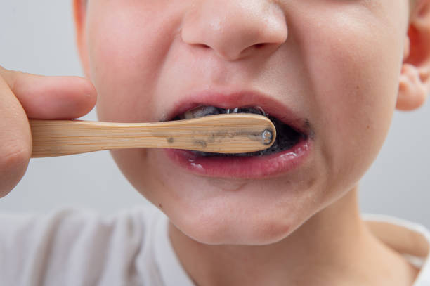 istock 7-year-old boy without one milk tooth brushes his teeth with a bamboo brush 1638300405