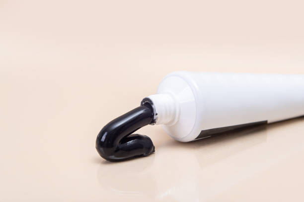 istock White tube with black toothpaste on a beige background. 1638300438