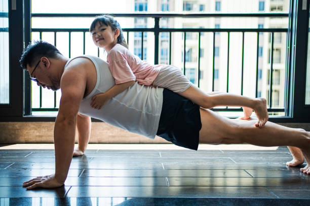 Father doing push ups with his child on his back Warm atmosphere of Asian families，Daughter sleeps on dad's back, dad does push ups human back stock pictures, royalty-free photos & images