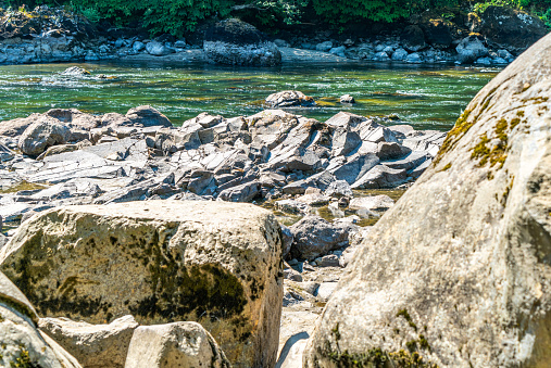 Large rocks line the shore of the Snoqualmie River in Washington State.