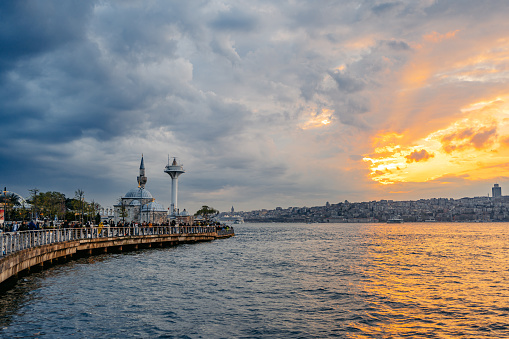 Beautiful sunset over the sea in Uskudar district and Mihrimah Sultan Mosque in a distance in Istanbul, Turkey.