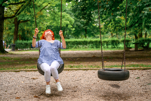 Joyous Father Pushes Swings with His Cute Little Daughter on Them. Happy Family Spends Time Together one Sunny Summer Day in the Idyllics Backyard.