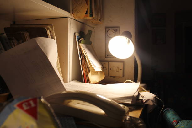 istock A lamp lighting up a desk with sheets and a landline on it 1638406610