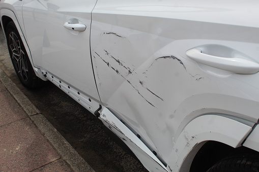 A close up photo of a scratch on a car's exterior.