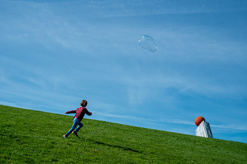 a child plays with some soap bubbles in the sky