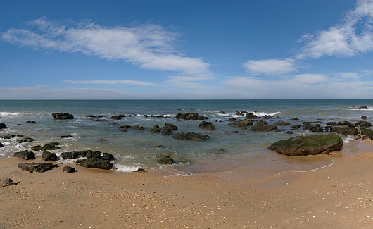 West Africa, Senegal. The sandy beach of the resort area is surrounded by rocks and fragments of rocks of volcanic origin.