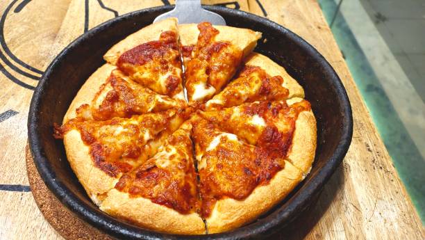 istock pizza served in black pan on wooden table 1638453613