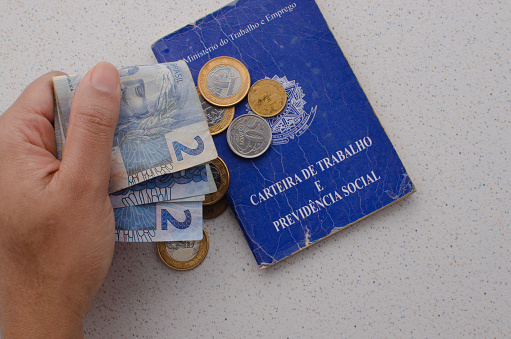 Brazil Work Card. Translation - Federative Republic of Brazil, Ministry of Labor. Brazil work card with money on the side. symbolizing the importance of employment and finance.