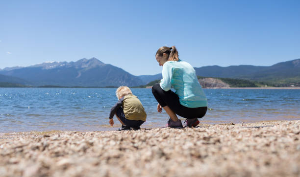 istock Happy mother son looking for shells on the beach. 1638506421