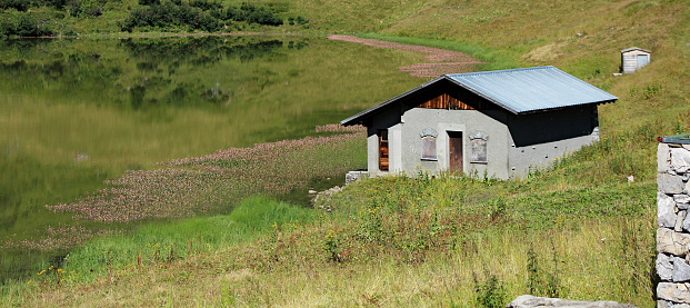 small shack at an alpine lake shore