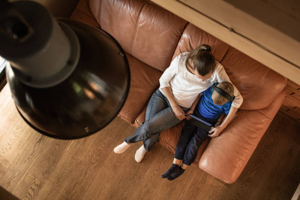istock Mother and son relaxing at home sitting in living room using computer tablet. 1638518161