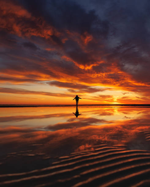 istock silhouette person against background beautiful sunset sky on ocean, reflection rays sun in water 1638542255