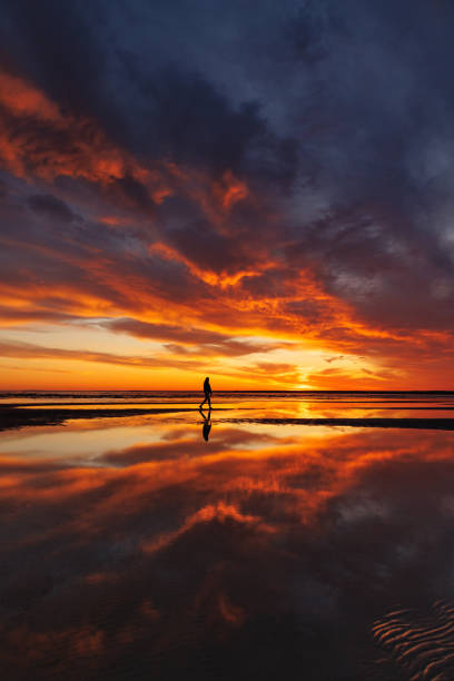 istock silhouette person against background beautiful sunset sky on ocean, reflection rays sun in water 1638542779