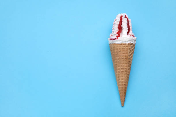 istock Delicious ice cream with raspberry jam in waffle cone on light blue background, top view. Space for text 1638545483