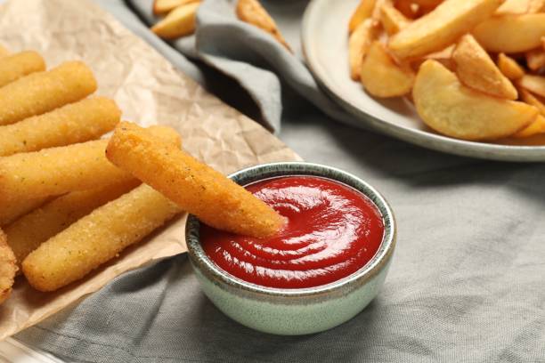 istock Delicious cheese sticks and ketchup on table, closeup 1638545502