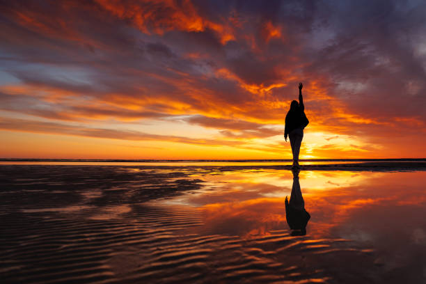 istock silhouette person against background beautiful sunset sky on ocean, reflection rays sun in water 1638551392