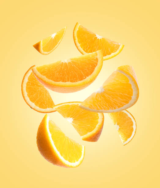 istock Juicy orange slices flying on pale golden background 1638554532