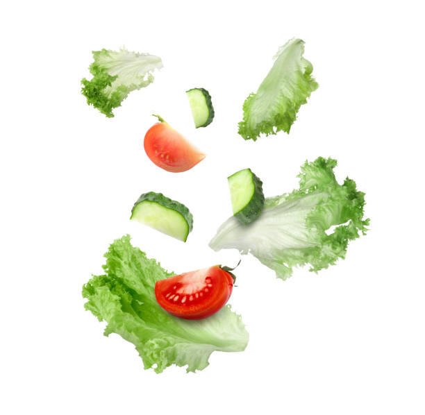 istock Lettuce leaves, cut cucumber and tomato falling on white background 1638555064