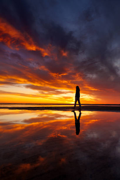 istock silhouette person against background beautiful sunset sky on ocean, reflection rays sun in water 1638556171