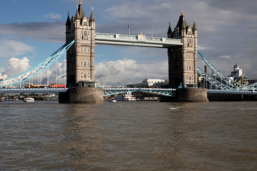 Tower Bridge over the Thames River in London, lit by the sun, after rain.