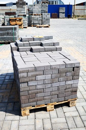 concrete paving slabs stacked on pallets in outside warehouse
