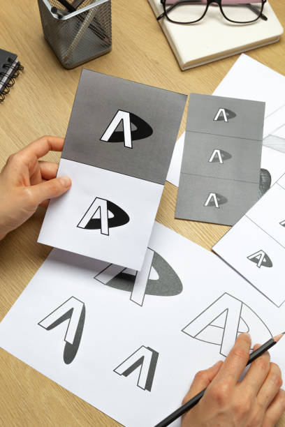 istock A graphic designer develops a logo for a brand. The illustrator draws sketches on paper. 1638618836