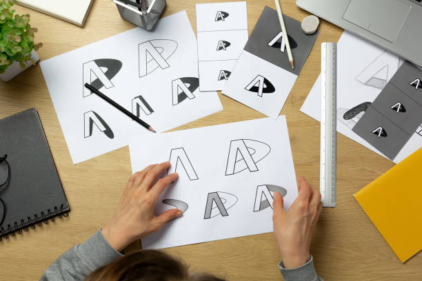 istock A graphic designer develops a logo for a brand. The illustrator draws sketches on paper. 1638619352