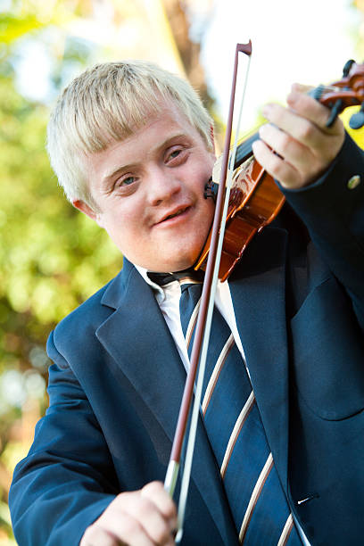 istock Cute handicapped boy playing violin. 163863164