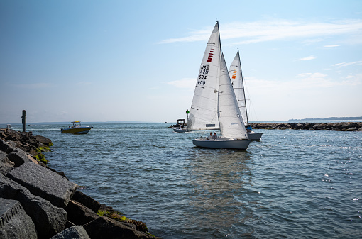 A variety of boats entering and leaving Falmouth Harbor in Falmouth, MA on Cape Cod.  A Busy harbor, there is a constant flow of boats including the Island Queen ferry out of the harbor into Vineyard Sound.