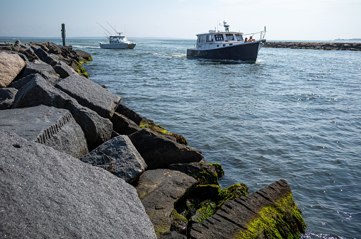 A variety of boats entering and leaving Falmouth Harbor in Falmouth, MA on Cape Cod.  A Busy harbor, there is a constant flow of boats including the Island Queen ferry out of the harbor into Vineyard Sound.