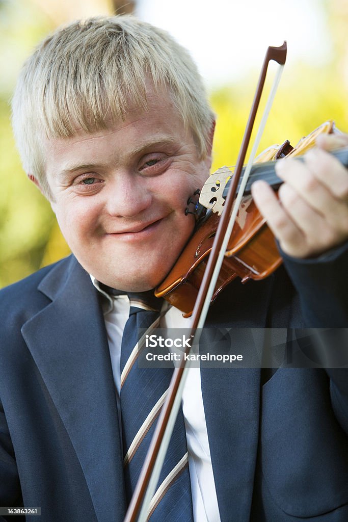 Cerrar el retrato de niño con un violín para personas con discapacidades. - Foto de stock de Niño libre de derechos