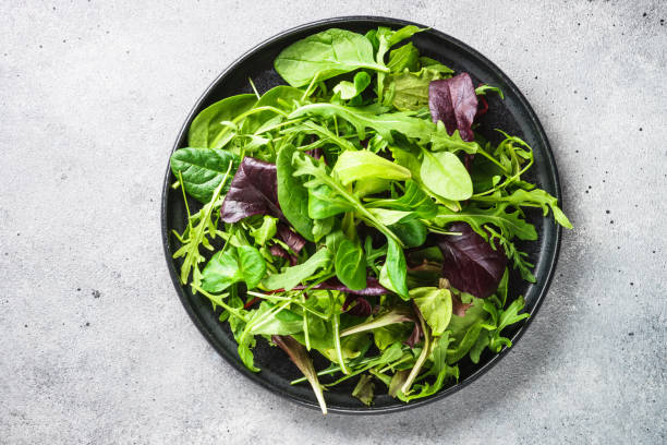 istock Salad from green leaves and vegetables on white. 1638637471