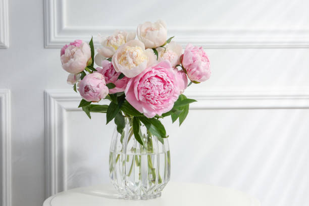 istock Beautiful peonies in glass vase on white table. Space for text 1638730160