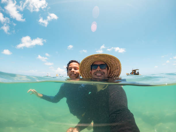 istock Father and son bathing on tropical beach 1638738971