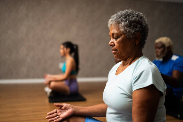 Senior woman metitating at a gym