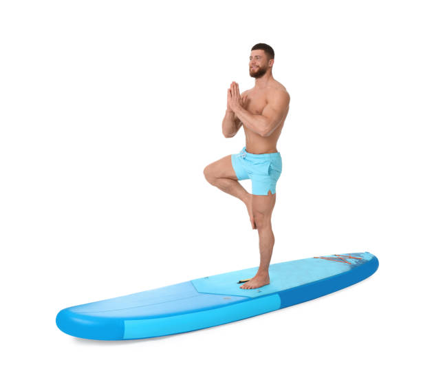 istock Happy man practicing yoga on blue SUP board against white background 1638754126