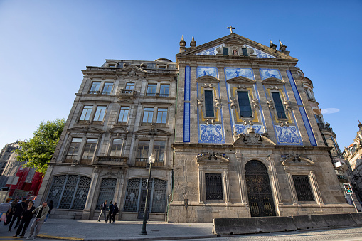 Street view of Igreja dos Congregados (Church of St Anthonys Congregation) in the afternoon, Porto, Portugal. People can be seen walking by.
