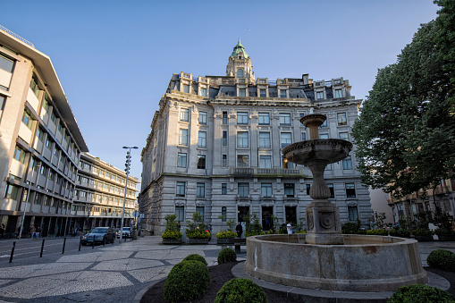 Back view of City Hall building in the morning, Porto, Portugal. A fountain and people can be seen.