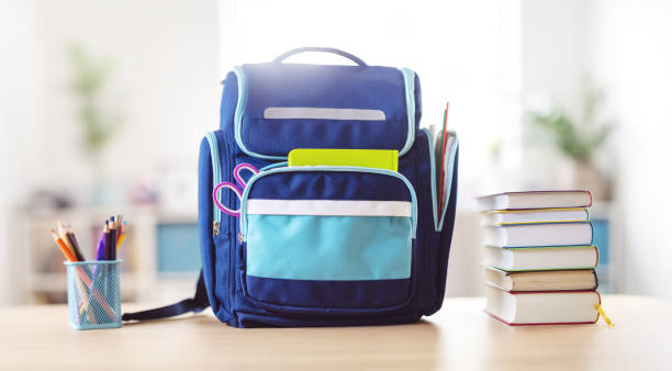 istock Blue backpack with stationery standing on the table indoors. 1638772491