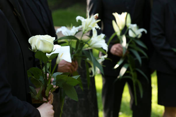 istock People with flowers outdoors, closeup. Funeral ceremony 1638779061